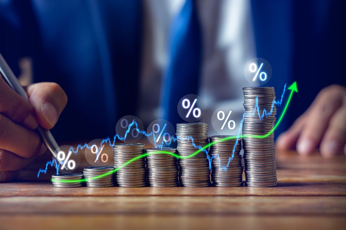 Businessman,Putting,Down,Money,,Pointing,With,Pen,And,Showing,Candlestick