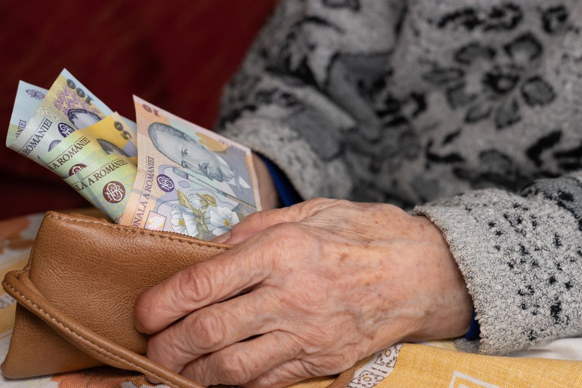 An,Old,Woman,Takes,Out,A,Small,Amount,Of,Romanian