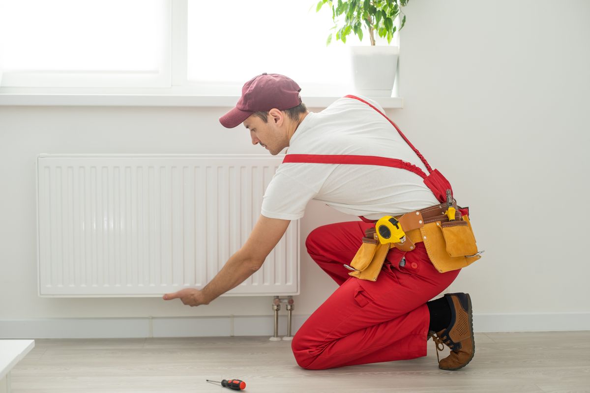 Man,In,Work,Overalls,Using,Wrench,While,Installing,Heating,Radiator