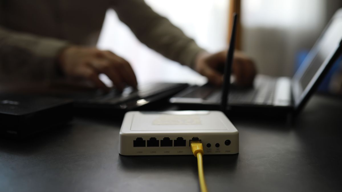 Modern,Dual,Band,Wireless,Router.,Man,Working,In,The,Background, szélessáv