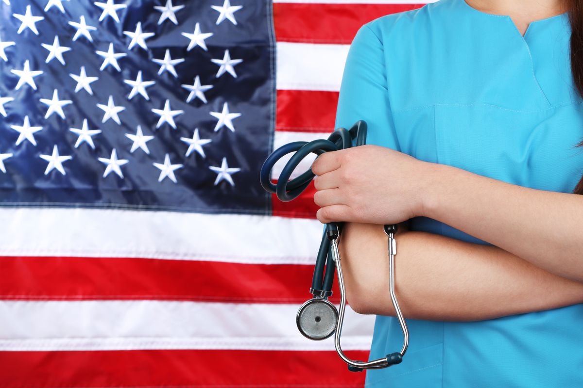 Female,Doctor,Holding,In,Hand,Stethoscope,With,Usa,Flag,On