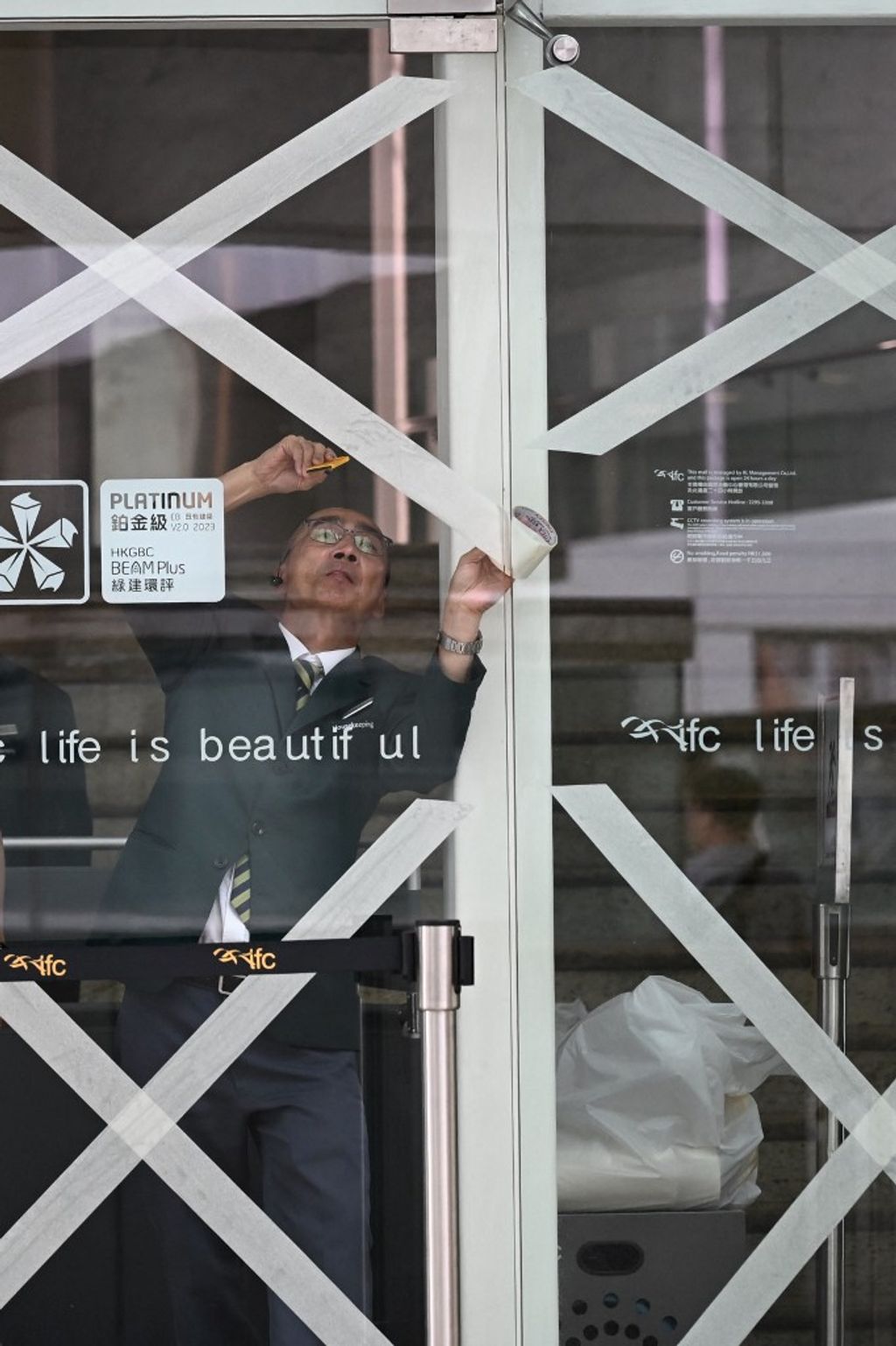 A worker tapes up windows in a shopping mall as Super Typhoon Ragasa approaches Hong Kong on September 23, 2025. Hong Kong rushed to prepare for the arrival of Super Typhoon Ragasa, with officials warning of a "serious threat" comparable to some of the mo