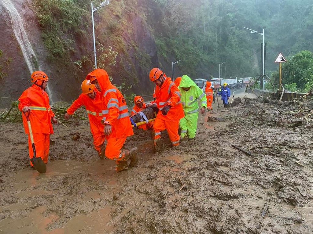 A handout photo taken on September 22, 2025 and received through the courtesy of Facebook page of Tuba Public Information Office on September 23, shows rescuers carrying an injured commuter on a stretcher after a landslide hit vehicles traversing a road a
