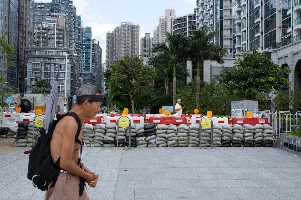 A man walks past sandbags prepared to hold back floodwaters, as Super Typhoon Ragasa approaches Hong Kong, on September 23, 2025. Hong Kong shut schools and cancelled flights on September 23 as Super Typhoon Ragasa was set to slam into the financial centr