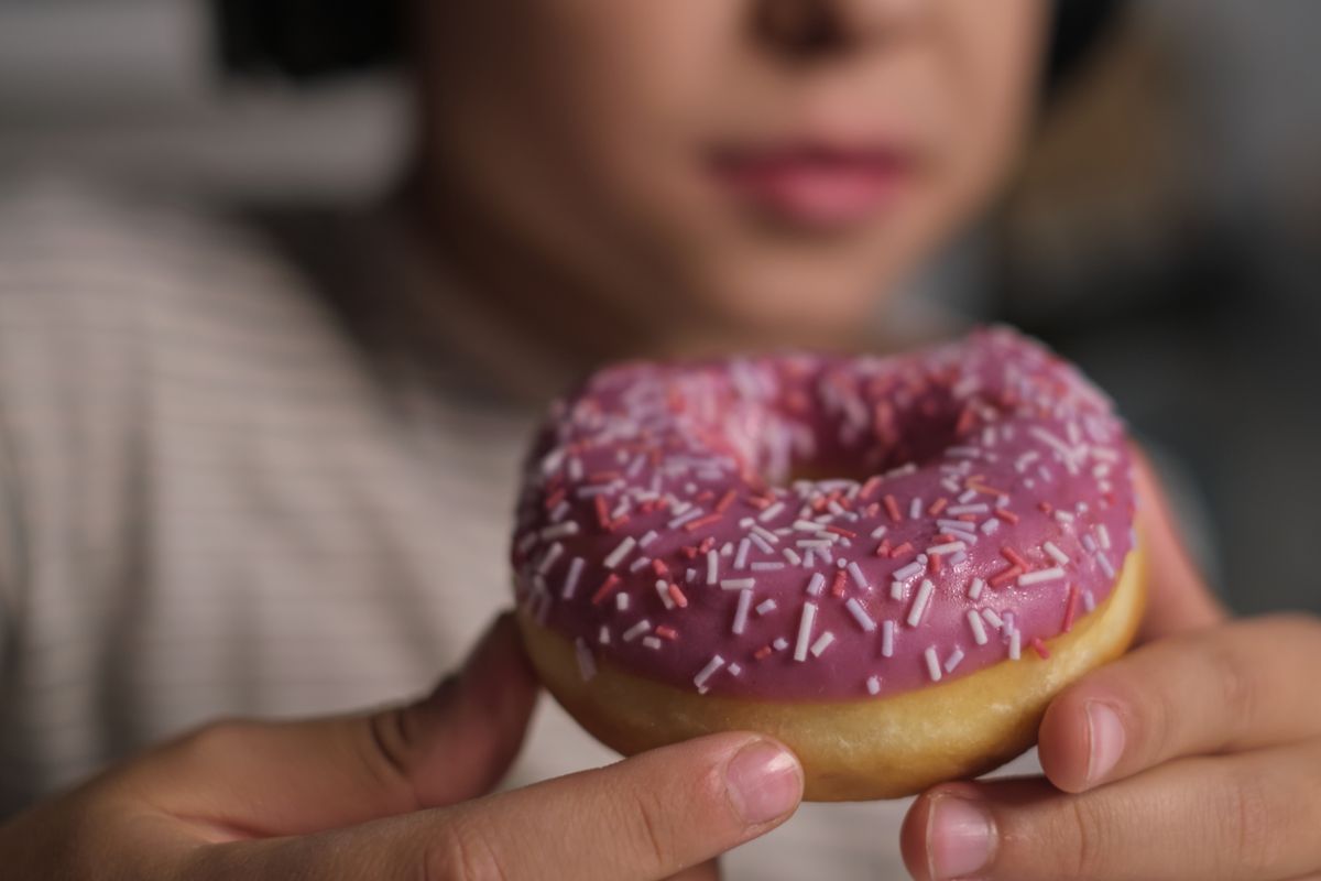 Child,Savoring,A,Brightly,Decorated,Donut,,Capturing,The,Sweet,And