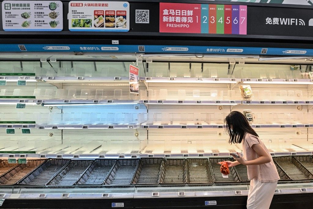 A woman buys groceries as empty shelves are seen at a supermarket in Shenzhen, in southern China's Guangdong province, on September 22, 2025, ahead of the landfall of the Super Typhoon Ragasa. The Chinese city of Shenzhen began preparing to evacuate 400,0
