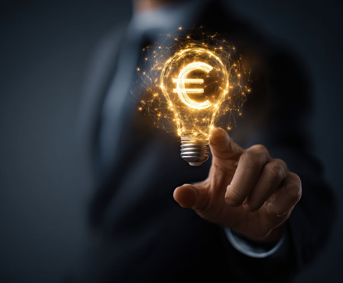 Businessman pointing euro currency sign inside light bulb