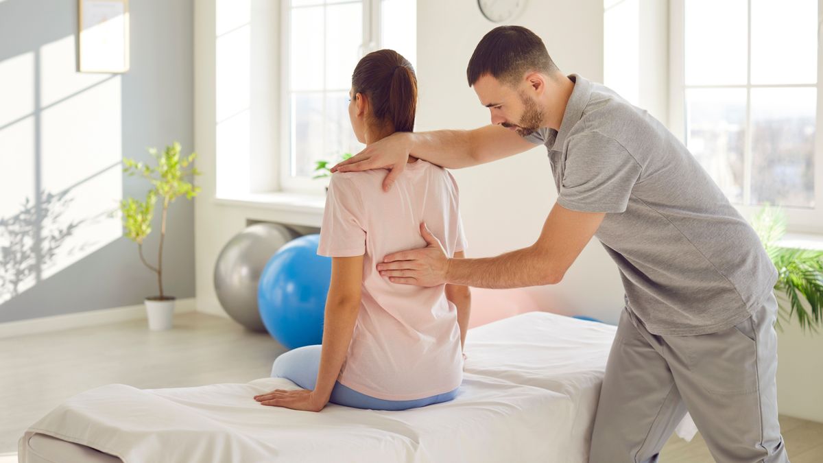 fájdalom,Male,Osteopath,Examining,Young,Woman,In,Modern,Office.,Young,Physiotherapist