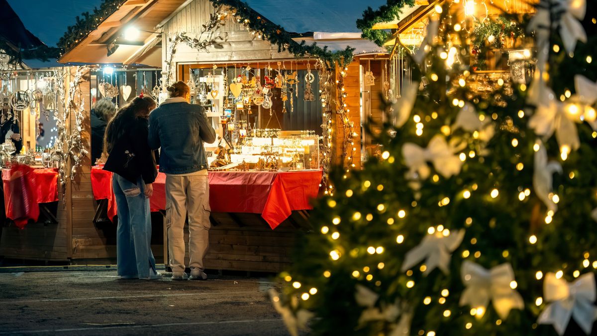 karácsony,Unidentified,People,Stand,Near,Illuminated,Wooden,Kiosk,With,Souvenirs,At
