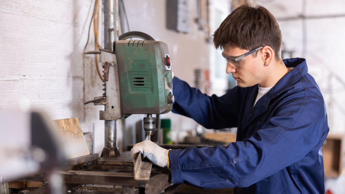 vállallat,Young,Male,Worker,Drilling,Holes,In,Metal,Part,With,Machine
