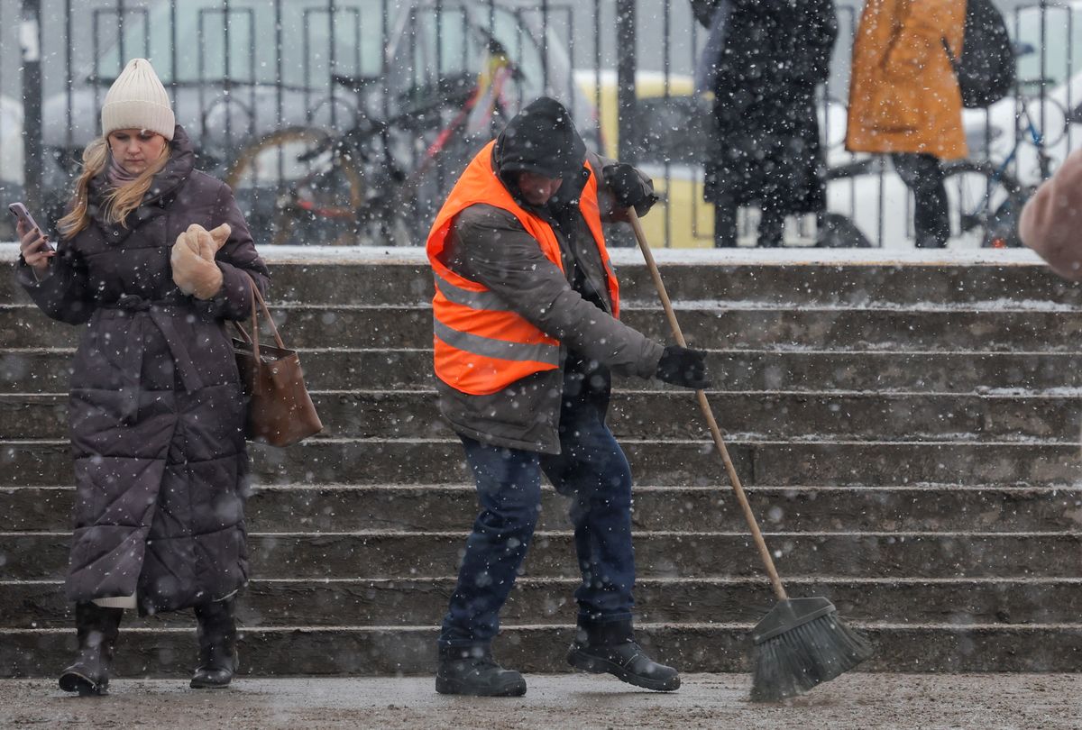A worker sweeps a staircase during a snowfall in Saint Petersburg