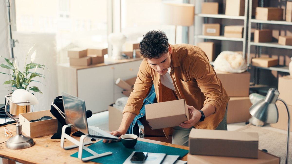 Laptop,,Ecommerce,And,Man,With,Box,In,Office,For,Stock, Minden vállalkozásnak legyen saját honlapja – mától pályázható az állami támogatás új honlapra és MI-fejlesztésekre kisvállalkozásoknak