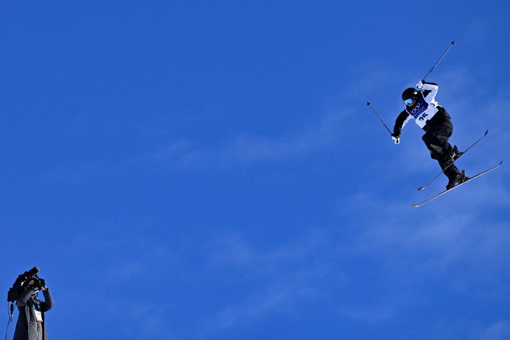 A camera operator films New Zealand's Sylvia Trotter as she competes in the freestyle skiing women's freeski slopestyle qualification run 2 during the Milano Cortina 2026 Winter Olympic Games at Livigno Snow Park, in Livigno (Valtellina), on February 7, 2