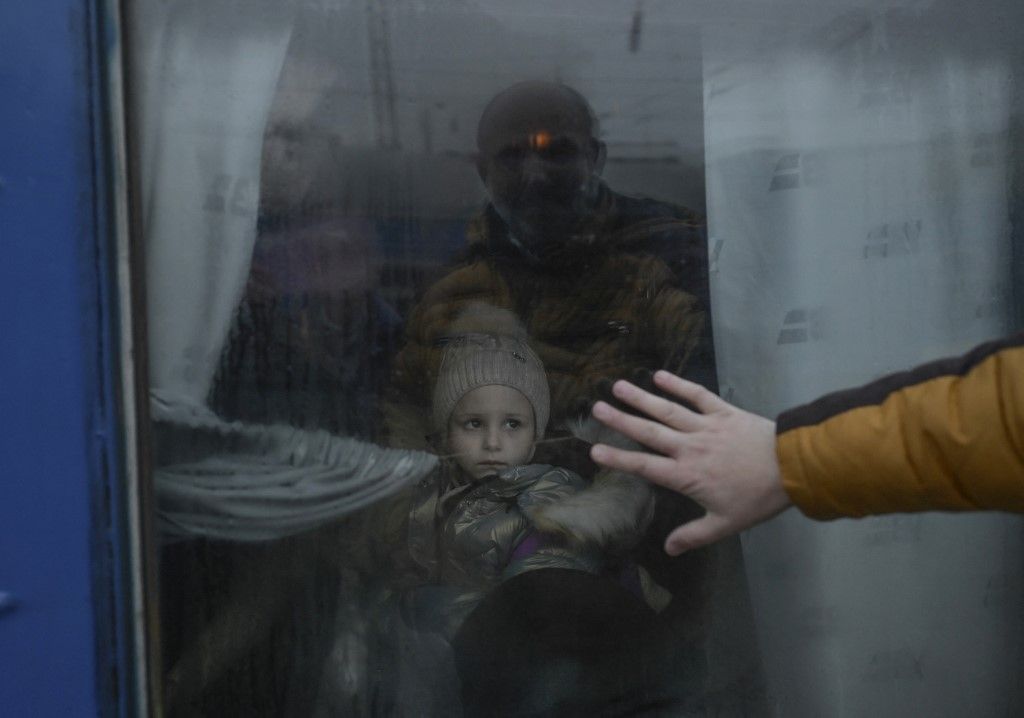(FILES) A father puts his hand on the window as he says goodbye to his daughter in front of an evacuation train at the central train station in Odessa on March 7, 2022. (Photo by BULENT KILIC / AFP)