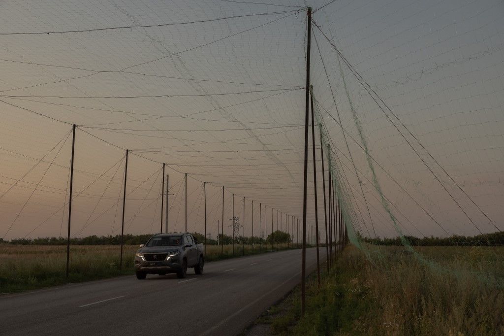 (FILES) A military car drives on a road under anti-drone nets installed by Ukrainian servicemen at an undisclosed location in the eastern Donetsk region on July 8, 2025, amid the Russian invasion of Ukraine. (Photo by Roman PILIPEY / AFP)