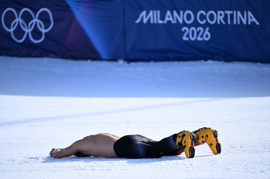 Austria's Benjamin Karl lies on the snow as he celebrates his victory in the snowboard men's parallel giant slalom final at Livigno Snow Park during the Milano Cortina 2026 Winter Olympic Games, in Livigno (Valtellina), on February 8, 2026. (Photo by Kiri