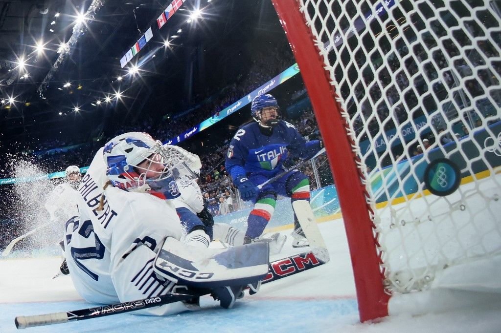 Italy's forward #12 Rebecca Roccella scores a goal past France's goalkeeper #32 Alice Philbert during the women's preliminary round group B Ice Hockey match between Italy and France at the Milano Santagiulia Ice Hockey Arena during the Milano Cortina 2026