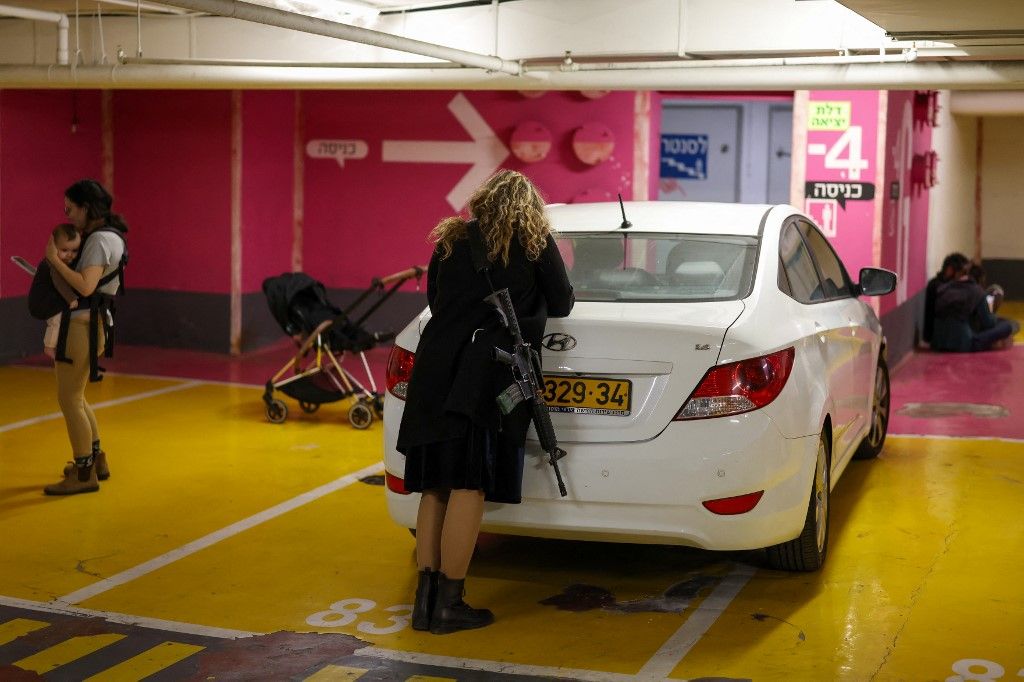 People take shelter in an underground garage in Tel Aviv on February 28, 2026. The United States and Israel launched a wave of strikes against targets in Iranian cities on February 28, triggering explosions and columns of smoke in the capital Tehran. Iran