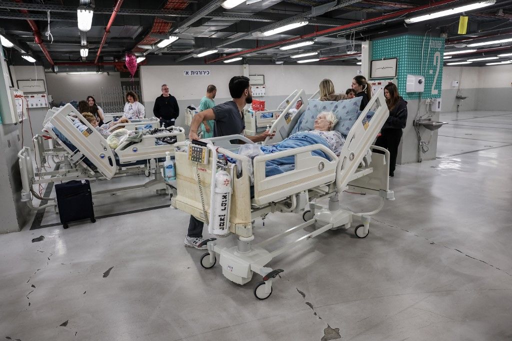Hospital staff move patients in a parking lot at Sourasky Medical Center for safety after sirens sounded in Tel Aviv on February 28, 2026, following the announcement that Israel had launched a “preemptive strike” on Iran. President Donald Trump urged Iran