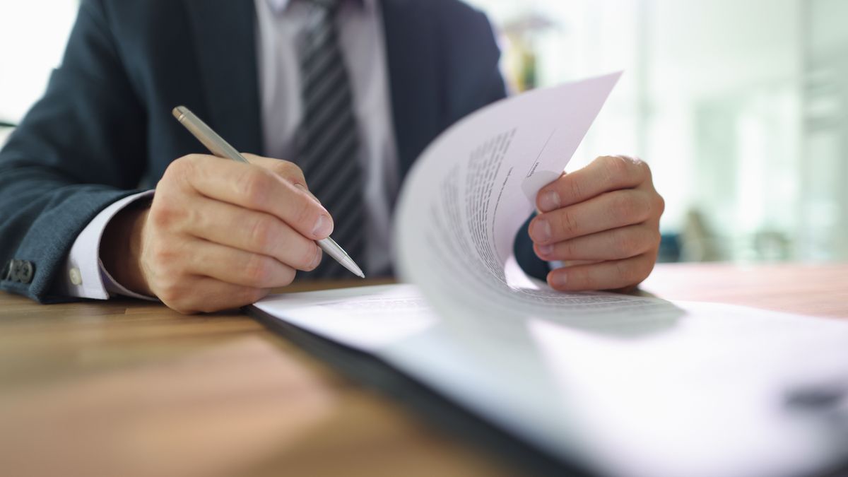 Confident,Male,Employee,Flips,Page,Of,Contract,Signing,After,Reading. Vezetőváltás a CIB Banknál – ő az új elnök