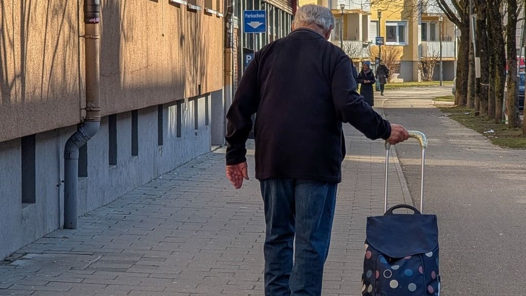 At-risk-of-poverty. Retiree With A Shopping Trolley In A Munich Residential Area nyugdíj