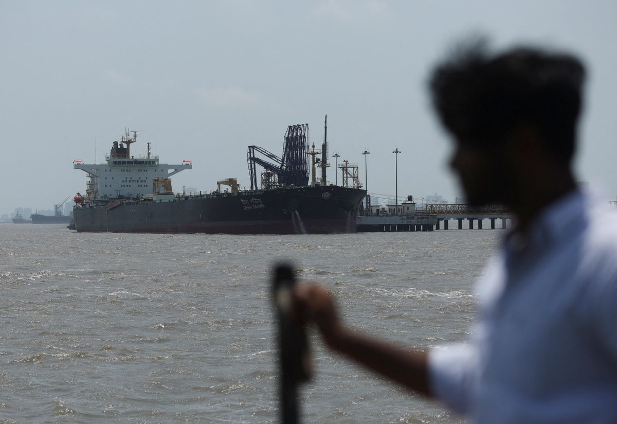 A man looks at India-flagged tanker Desh Garima, as it unloads crude oil at an offloading terminal after transiting the Strait of Hormuz, amid supply disruptions linked to the U.S.-Israeli conflict with Iran, in Mumbai