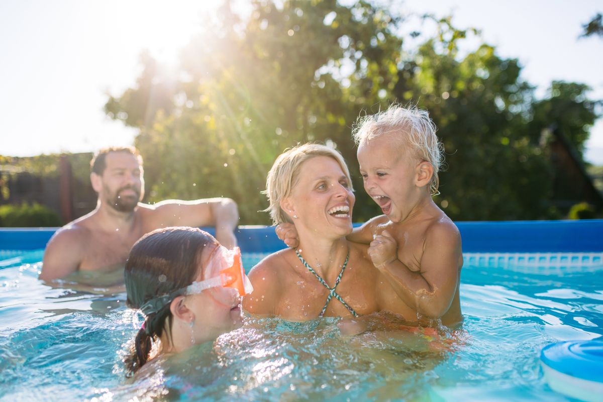 Young,Family,With,Two,Children,In,Swimming,Pool,Outdoors,In család hőség