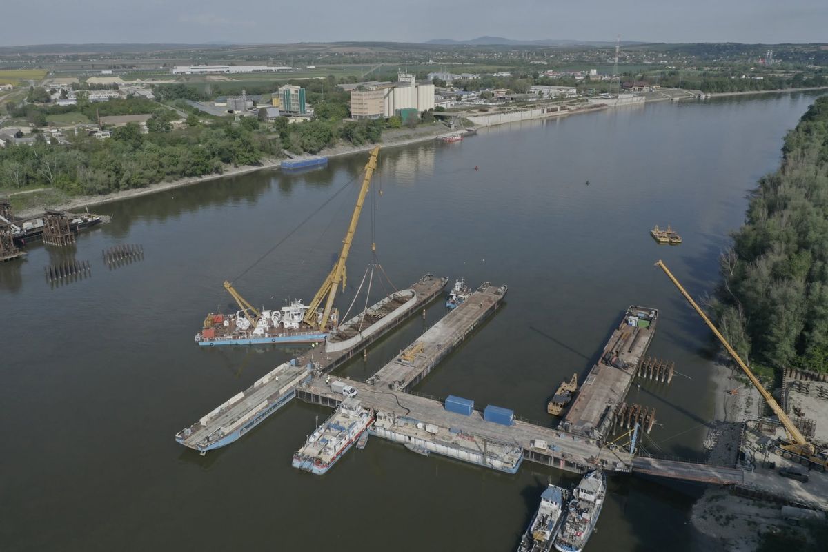 Fotókon Magyarország legnagyobb beruházása: kulcspillanathoz ért a mohácsi Duna-híd építése, leállították a hajóforgalmat – beemelték a betonszörnyet a mederbe