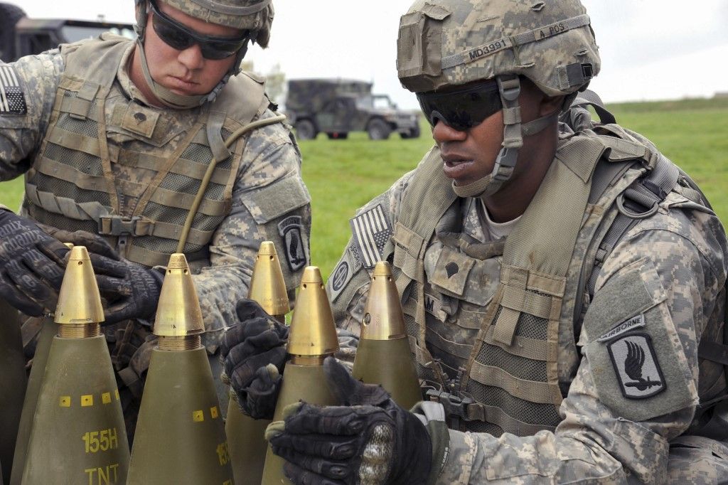 U.S. Army paratroopers prepare 155mm rounds for firing with M777A2 Howitzers