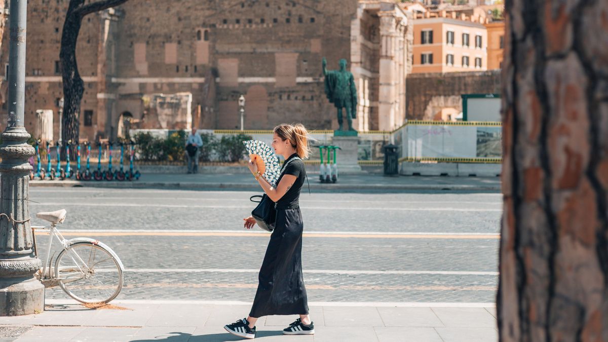 Woman,Walking,Along,A,Sunny,Street,In,Rome,Holding,A, hőkupola