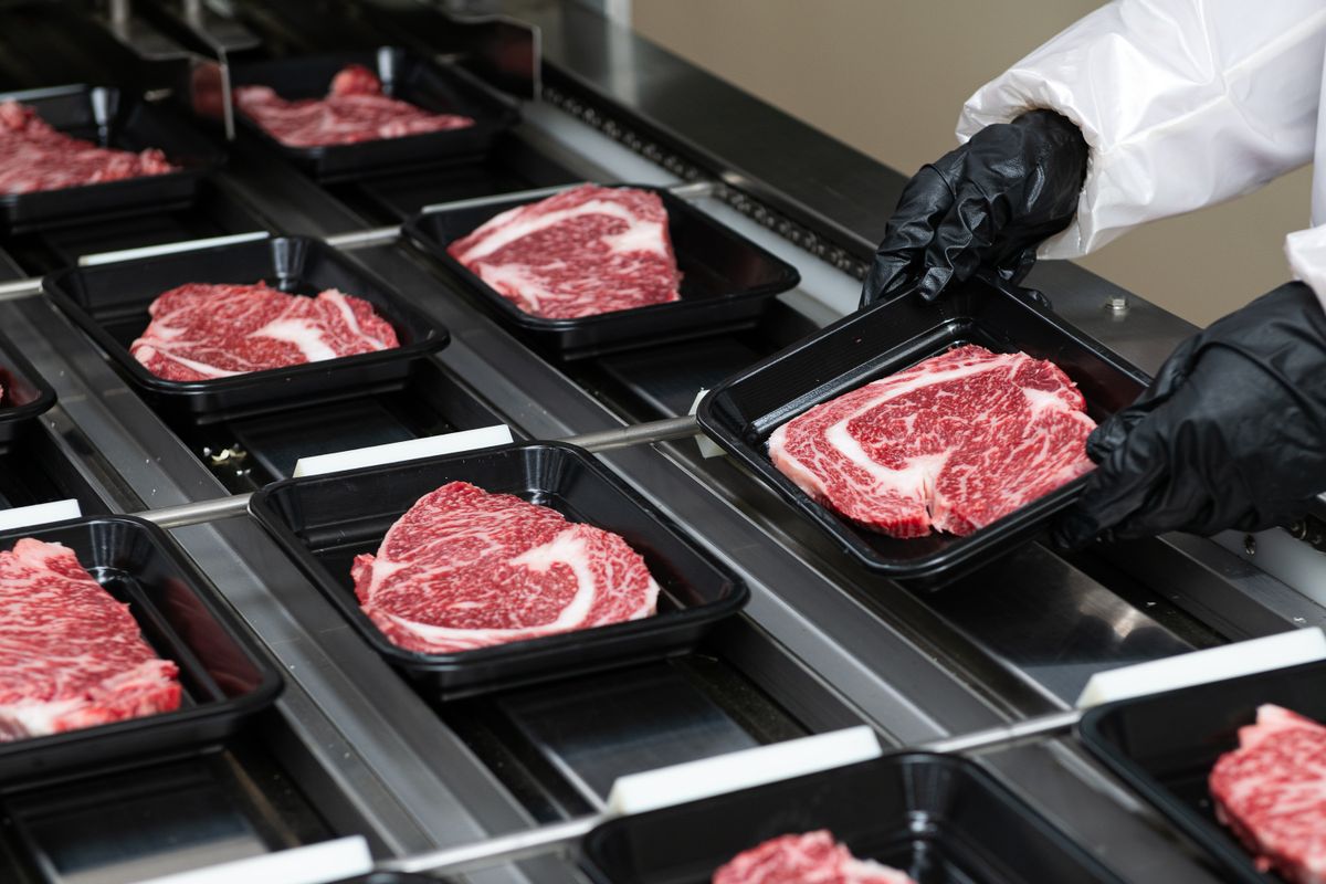 Steaks,On,A,Conveyor,Belt,Being,Packaged,In,A,Food