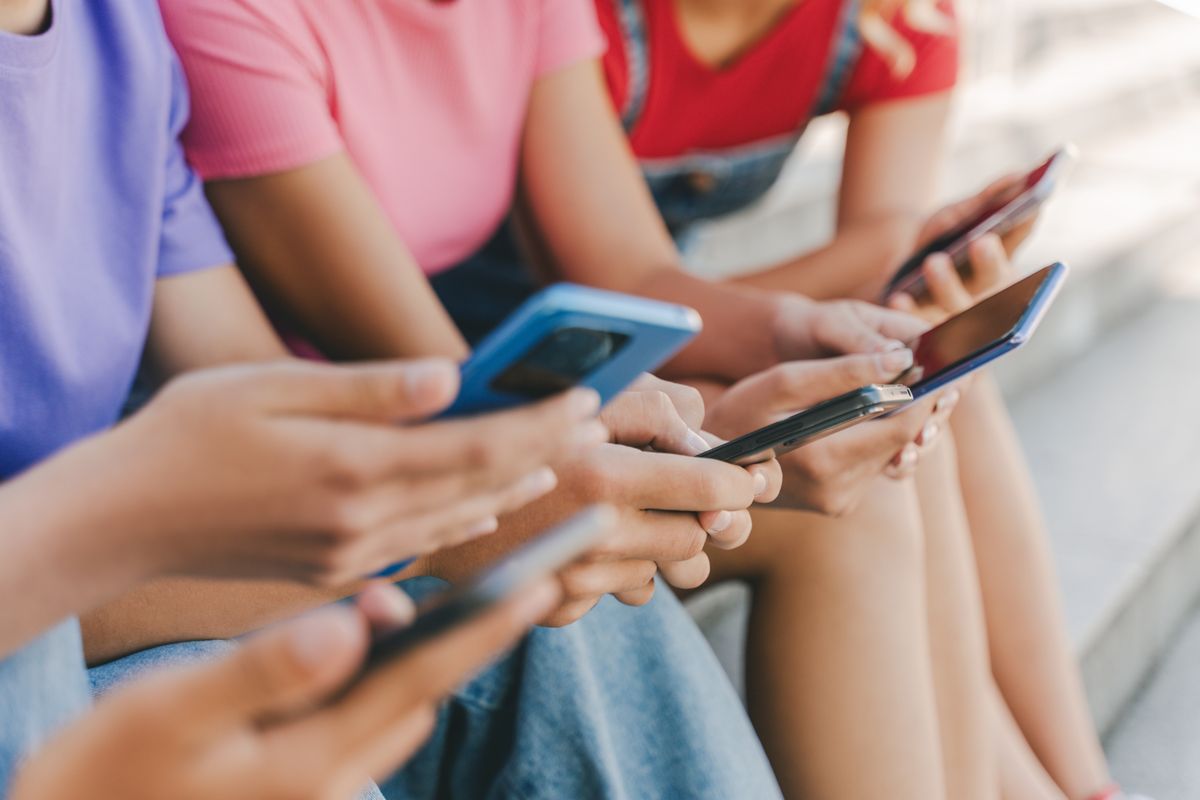 Closeup,,Group,Of,Teenagers,Holding,Mobile,Phones,Watching,Video,,Communication közösségi média gyerek