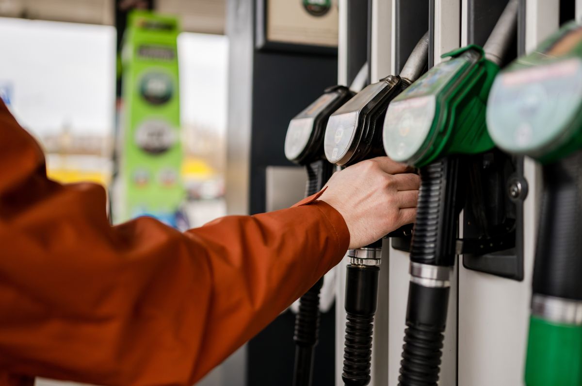 Man,Grabbing,A,Fuel,Pump,At,A,Gas,Station,Refueling benzin üzemanyag